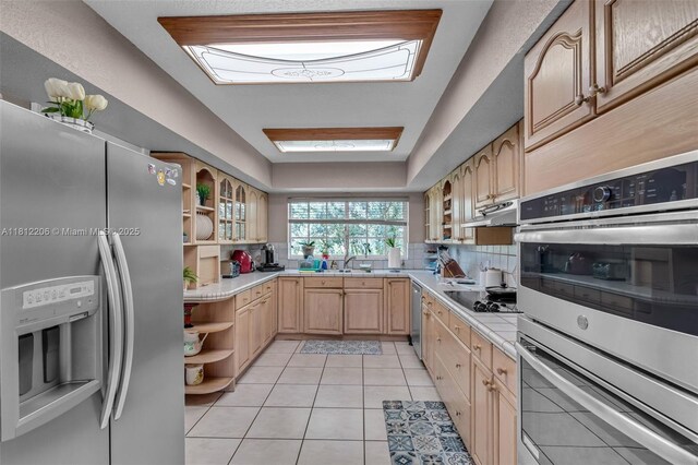 17550 SW 59th Ct, Southwest Ranches, FL 33331 - kitchen with appliances with stainless steel finishes, open shelves, light brown cabinetry, light countertops, and backsplash