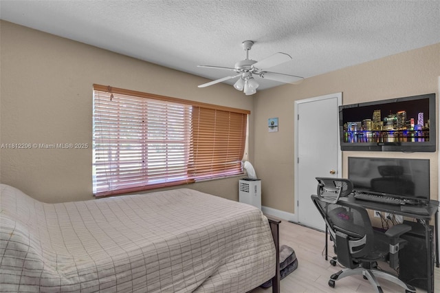 17550 SW 59th Ct, Southwest Ranches, FL 33331 - bedroom with an office area, a textured ceiling, a ceiling fan, and light wood-type flooring