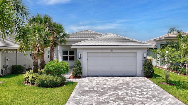 13349 SW Ibis Shores Rd, Port St Lucie, FL 34987 - ranch-style home featuring a front lawn, decorative driveway, a garage, and stucco siding