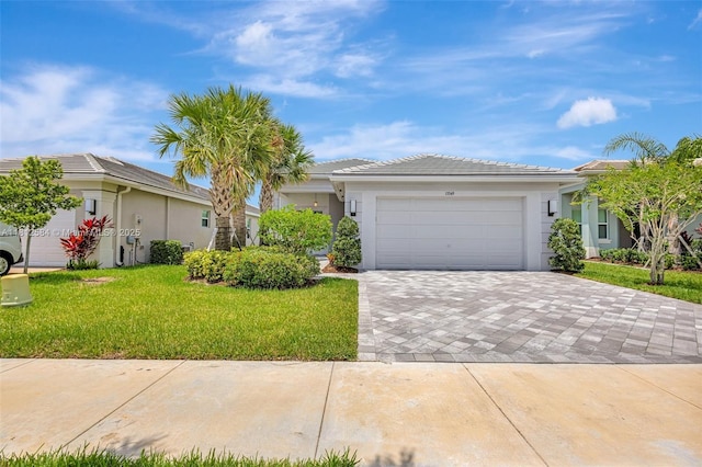 13349 SW Ibis Shores Rd, Port St Lucie, FL 34987 - view of front of home featuring a front yard, decorative driveway, an attached garage, stucco siding, and a tiled roof