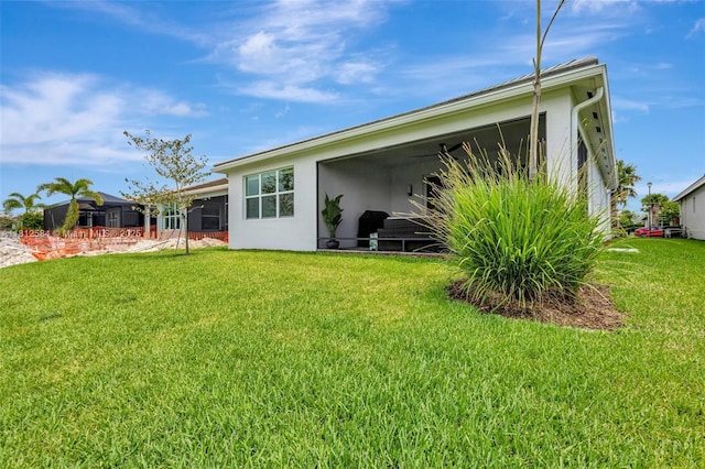 13349 SW Ibis Shores Rd, Port St Lucie, FL 34987 - back of house featuring a sunroom and a lawn