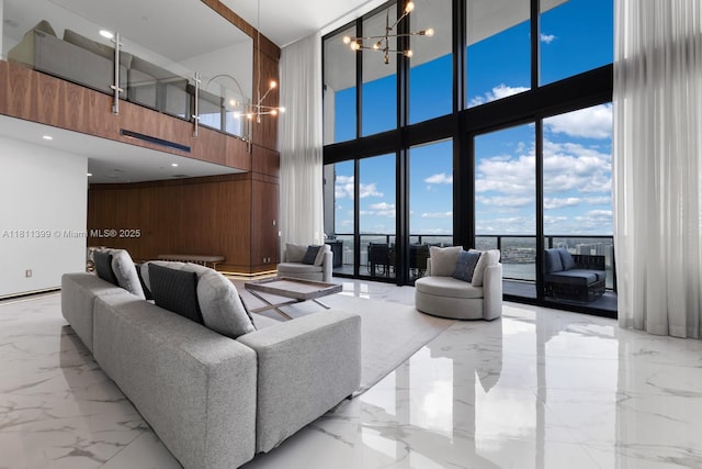 18555 Collins Ave Unit 4603, Sunny Isles Beach, FL 33160 - living area featuring a towering ceiling, light marble finish floors, wooden walls, a chandelier, and expansive windows