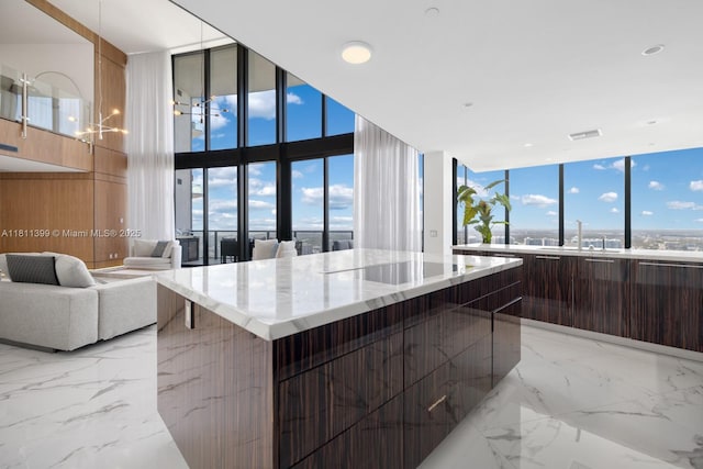 18555 Collins Ave Unit 4603, Sunny Isles Beach, FL 33160 - kitchen with modern cabinets, light marble finish floors, a spacious island, light stone countertops, and expansive windows