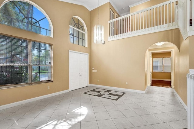 2434 SW 157th Ave, Miramar, FL 33027 - entrance foyer with ornamental molding, tile patterned flooring, a high ceiling, baseboards, and arched walkways