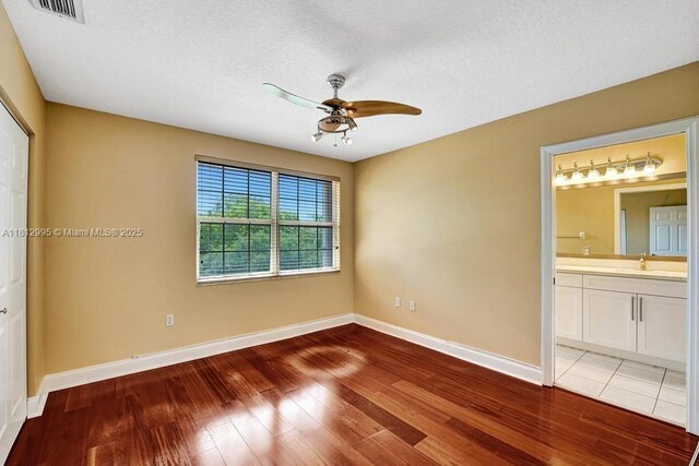 2434 SW 157th Ave, Miramar, FL 33027 - unfurnished bedroom with light wood-style flooring, baseboards, a sink, ensuite bath, and ceiling fan