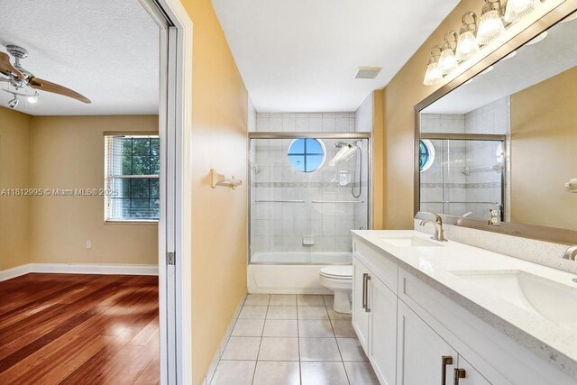 2434 SW 157th Ave, Miramar, FL 33027 - bathroom featuring toilet, double vanity, shower / bath combination with glass door, ceiling fan, and baseboards