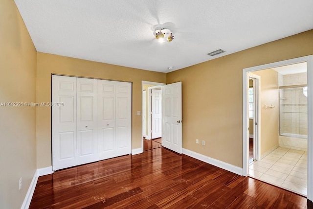 2434 SW 157th Ave, Miramar, FL 33027 - unfurnished bedroom with a closet, wood finished floors, baseboards, and ensuite bath