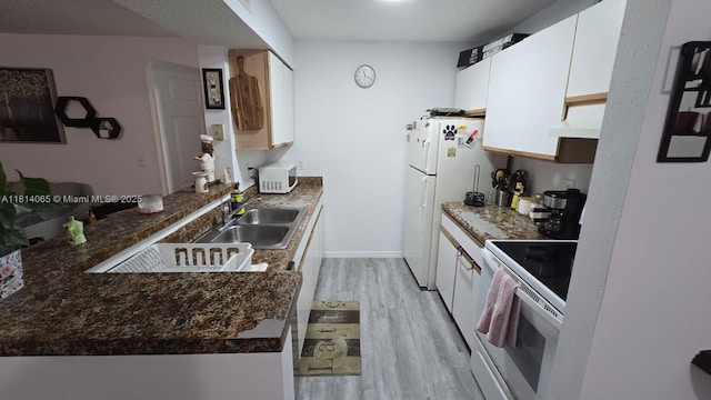 3995 W Mcnab Rd Unit B212, Pompano Beach, FL 33069 - kitchen featuring white appliances, light wood-type flooring, white cabinets, range hood, and a peninsula