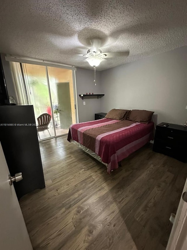 3995 W Mcnab Rd Unit B212, Pompano Beach, FL 33069 - bedroom featuring wood finished floors, access to outside, a textured ceiling, expansive windows, and ceiling fan