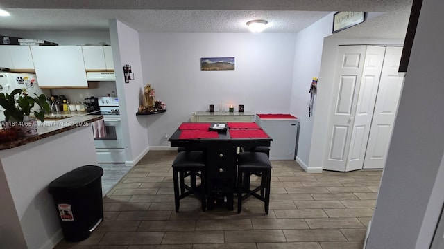 3995 W Mcnab Rd Unit B212, Pompano Beach, FL 33069 - dining space featuring a textured ceiling and baseboards