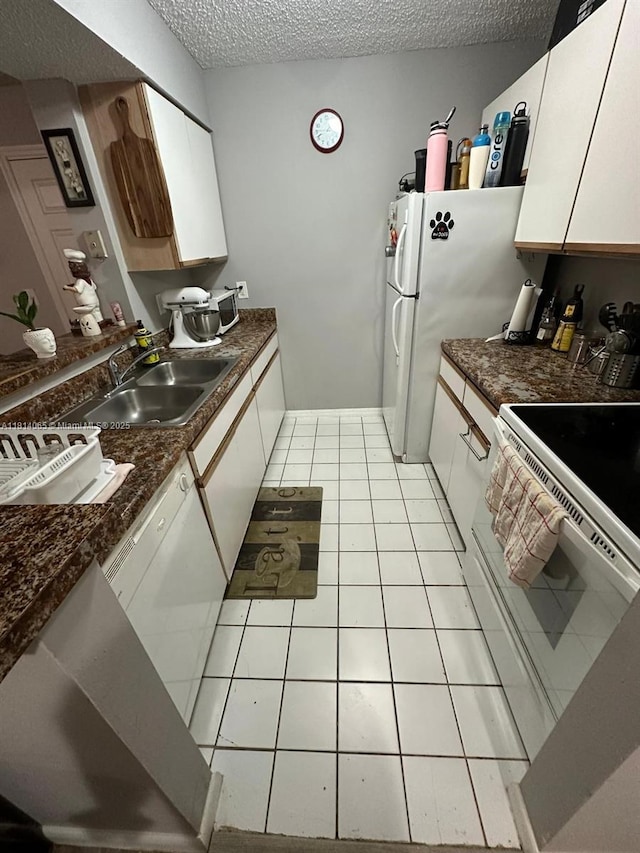 3995 W Mcnab Rd Unit B212, Pompano Beach, FL 33069 - kitchen featuring a sink, white appliances, a textured ceiling, white cabinetry, and light tile patterned floors
