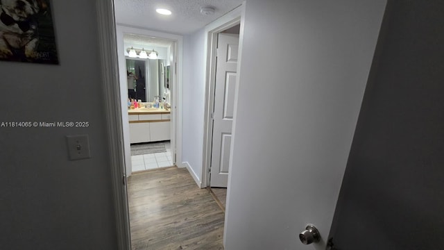 3995 W Mcnab Rd Unit B212, Pompano Beach, FL 33069 - hall featuring a textured ceiling and wood finished floors
