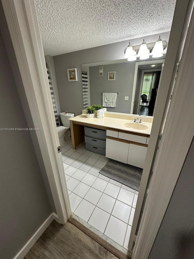 3995 W Mcnab Rd Unit B212, Pompano Beach, FL 33069 - bathroom with vanity, toilet, tile patterned flooring, and a textured ceiling