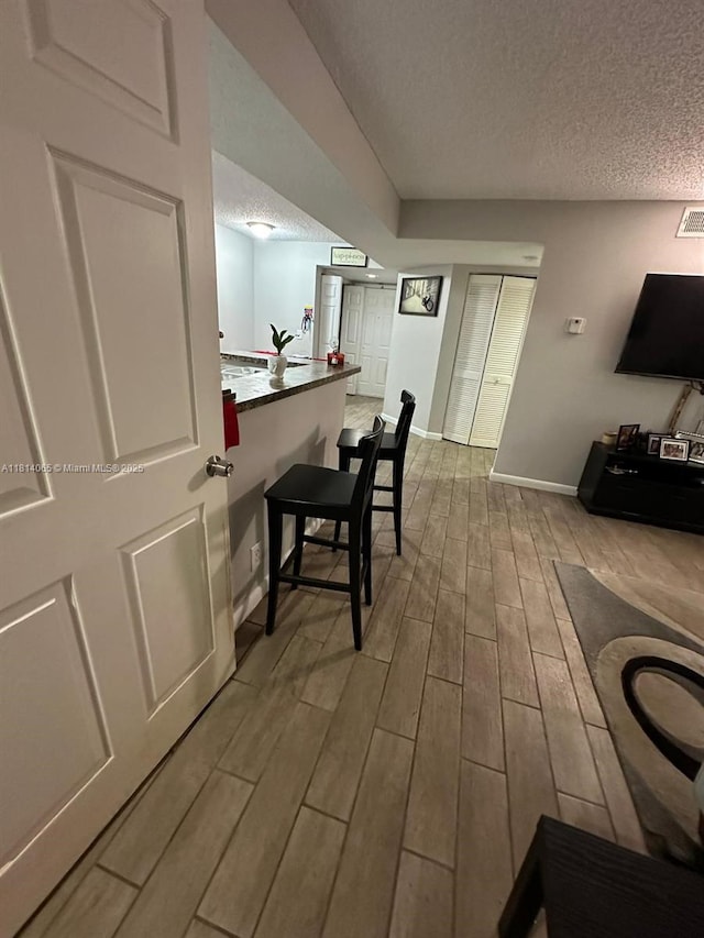 3995 W Mcnab Rd Unit B212, Pompano Beach, FL 33069 - dining area with a textured ceiling, wood finished floors, and baseboards