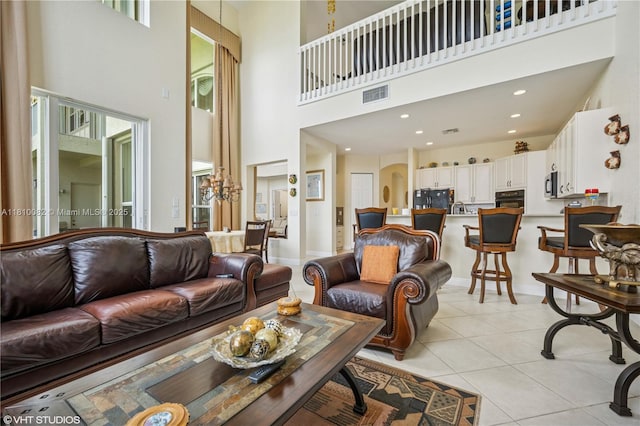 living area featuring a high ceiling, light tile patterned floors, and arched walkways