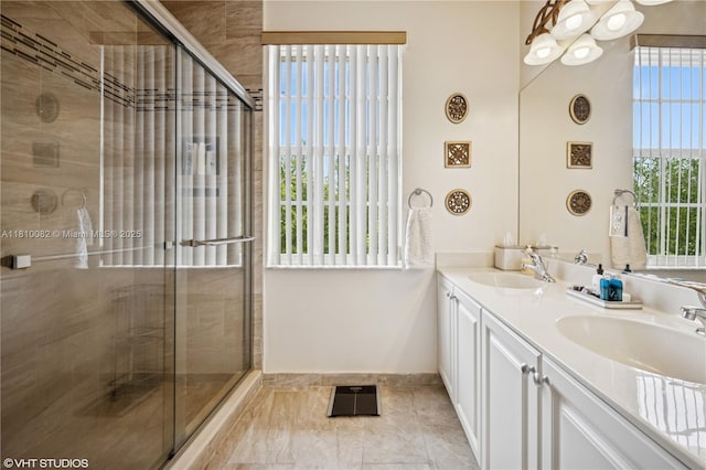 bathroom featuring double vanity, a shower stall, and baseboards