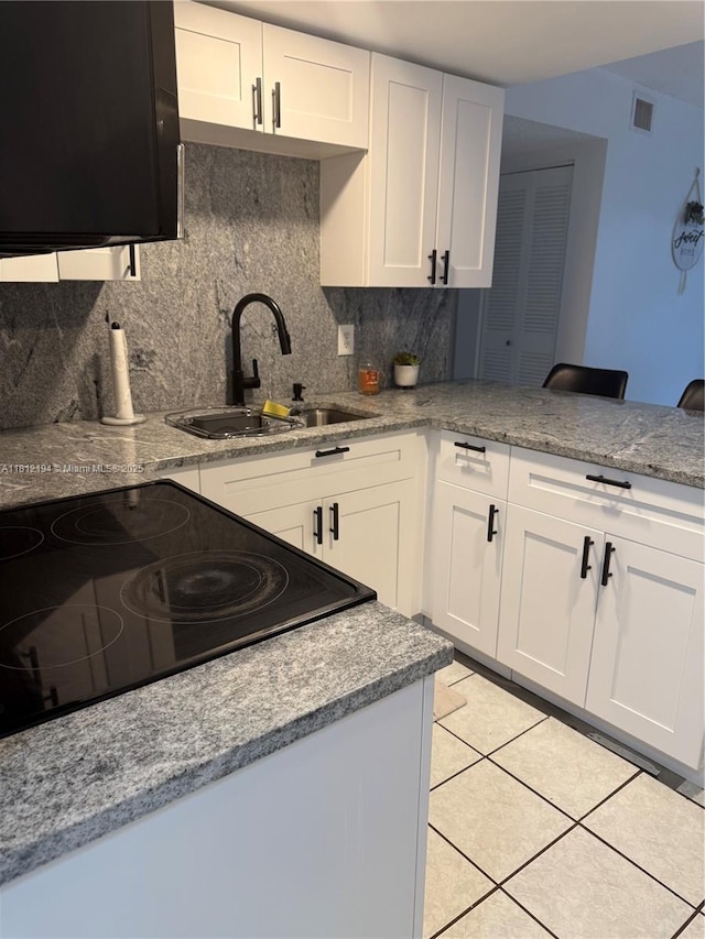 10661 SW 108th Ave Unit 2E, Miami, FL 33176 - kitchen featuring a sink, backsplash, white cabinets, a peninsula, and light tile patterned floors