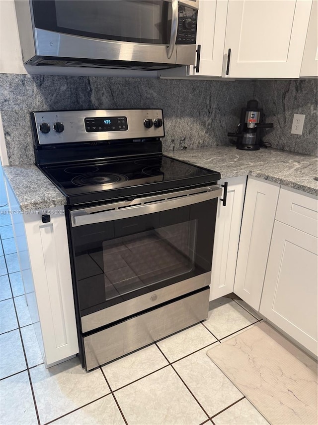 10661 SW 108th Ave Unit 2E, Miami, FL 33176 - kitchen featuring appliances with stainless steel finishes, white cabinetry, backsplash, and light tile patterned floors