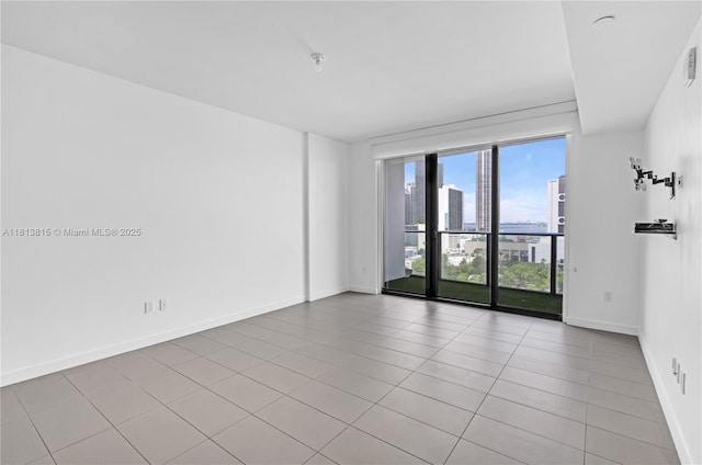 1600 NE 1st Ave Unit 1402, Miami, FL 33132 - tiled empty room featuring a city view and baseboards