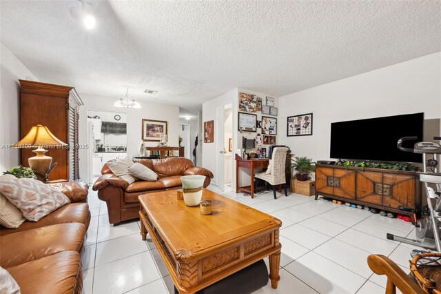 4119 NE 21st Ter, Lighthouse Point, FL 33064 - living room featuring a textured ceiling, a chandelier, and light tile patterned floors