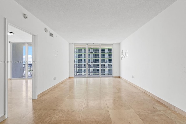 1750 N Bayshore Dr Unit 2809, Miami, FL 33132 - empty room featuring a wall of windows, a textured ceiling, and baseboards