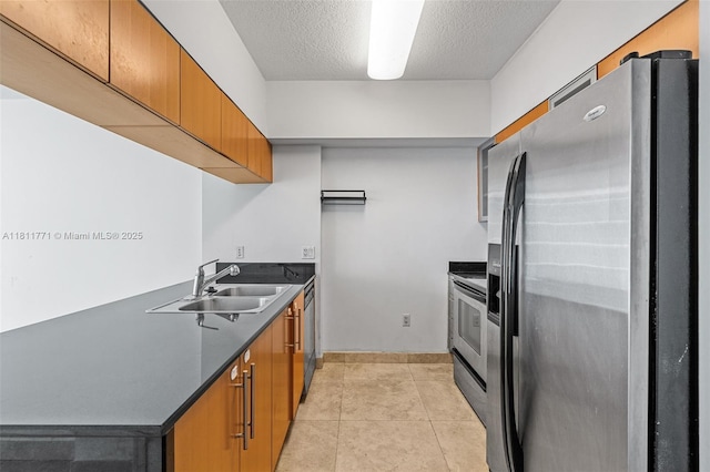 1750 N Bayshore Dr Unit 2809, Miami, FL 33132 - kitchen with stainless steel appliances, dark countertops, a sink, a textured ceiling, and light tile patterned flooring