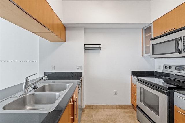 1750 N Bayshore Dr Unit 2809, Miami, FL 33132 - kitchen with appliances with stainless steel finishes, a sink, dark countertops, baseboards, and brown cabinetry