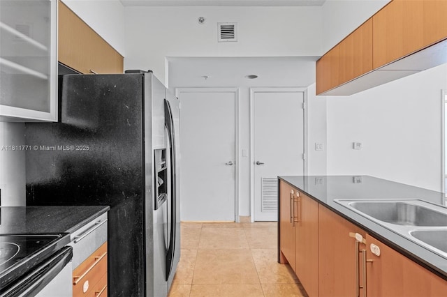 1750 N Bayshore Dr Unit 2809, Miami, FL 33132 - kitchen with stainless steel fridge with ice dispenser, light tile patterned floors, dark countertops, and glass insert cabinets