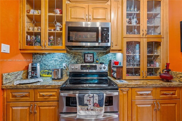 461 Morningside Dr, Miami Springs, FL 33166 - kitchen with stainless steel appliances, glass insert cabinets, decorative backsplash, and brown cabinets