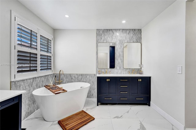 16331 SW 23rd St, Miramar, FL 33027 - bathroom featuring double vanity, tile walls, marble look tile flooring, a soaking tub, and wainscoting