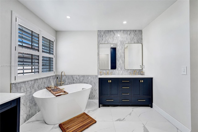 16331 SW 23rd St, Miramar, FL 33027 - full bath featuring double vanity, tile walls, marble finish floors, a soaking tub, and a wainscoted wall
