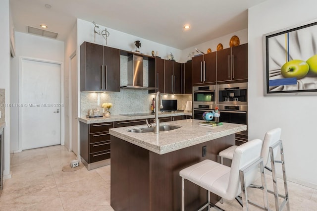 900 Brickell Key Blvd Unit 1702, Miami, FL 33131 - kitchen with wall chimney range hood, a sink, decorative backsplash, a kitchen bar, and recessed lighting