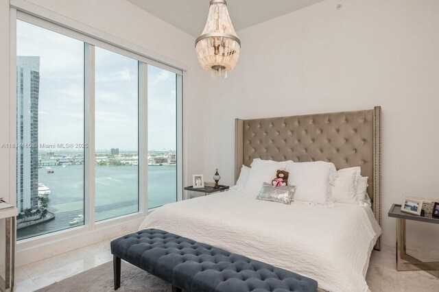 900 Brickell Key Blvd Unit 1702, Miami, FL 33131 - bedroom featuring multiple windows, a chandelier, a city view, and a water view