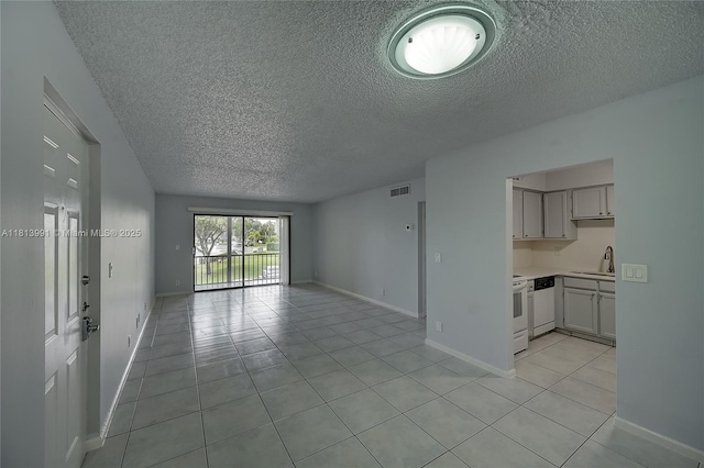 9965 Pineapple Tree Dr Unit 203, Boynton Beach, FL 33436 - unfurnished living room featuring a textured ceiling and light tile patterned floors