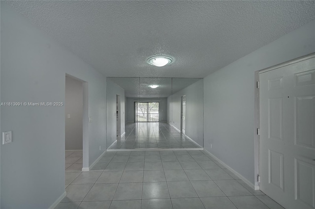 9965 Pineapple Tree Dr Unit 203, Boynton Beach, FL 33436 - hallway featuring a textured ceiling and light tile patterned floors
