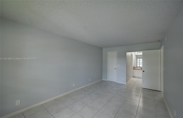 9965 Pineapple Tree Dr Unit 203, Boynton Beach, FL 33436 - spare room with a textured ceiling and light tile patterned flooring