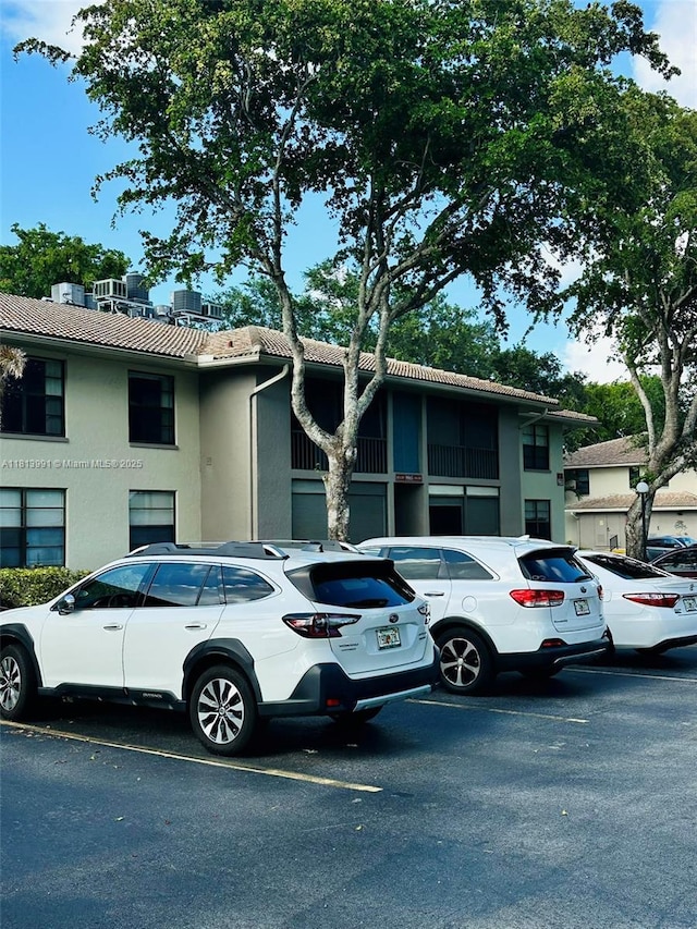 9965 Pineapple Tree Dr Unit 203, Boynton Beach, FL 33436 - view of front of house with uncovered parking, stucco siding, and a tiled roof