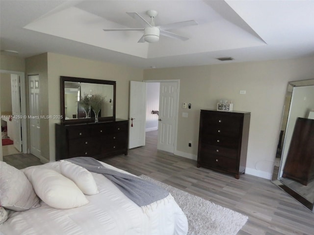 16815 SW 49th Ct, Miramar, FL 33027 - bedroom featuring light wood-style floors, a tray ceiling, and baseboards