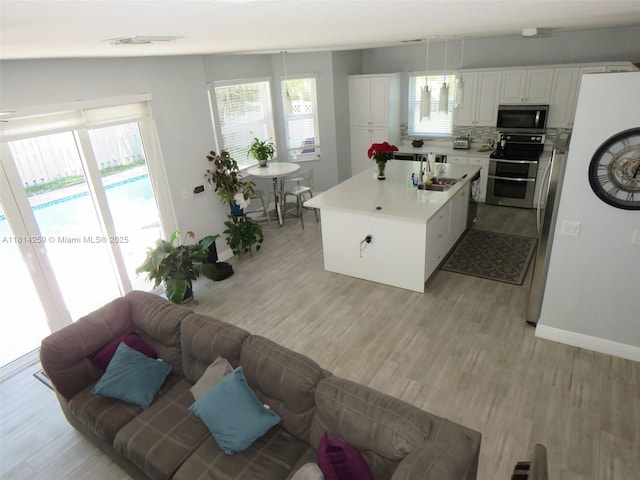 16815 SW 49th Ct, Miramar, FL 33027 - kitchen with appliances with stainless steel finishes, a sink, light wood-type flooring, and a center island