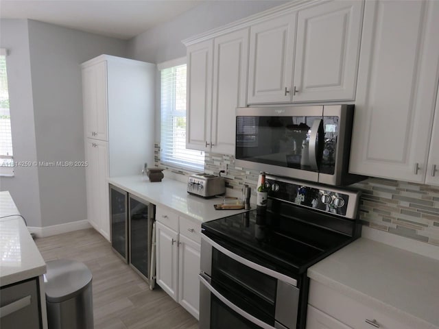 16815 SW 49th Ct, Miramar, FL 33027 - kitchen featuring appliances with stainless steel finishes, decorative backsplash, light wood finished floors, and white cabinets