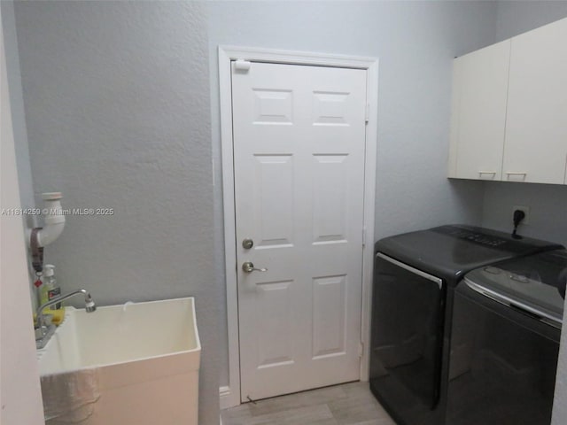 16815 SW 49th Ct, Miramar, FL 33027 - washroom with cabinet space, light wood-style floors, independent washer and dryer, and a textured wall