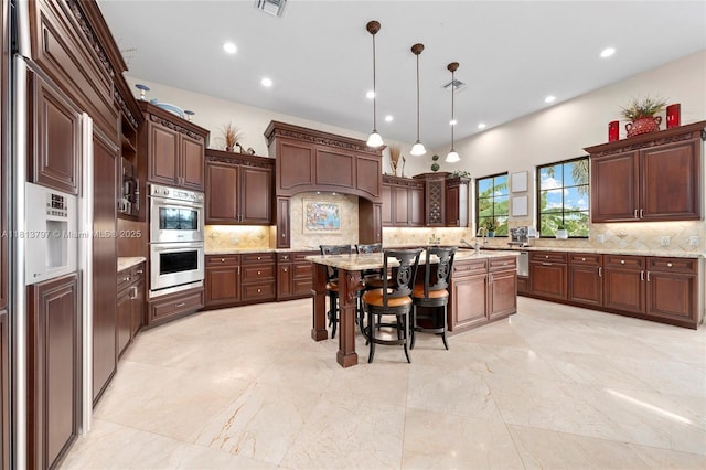 1437 SE 13th St, Deerfield Beach, FL 33441 - kitchen with stainless steel double oven, tasteful backsplash, a kitchen breakfast bar, pendant lighting, and recessed lighting