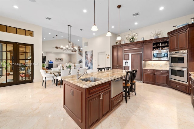 1437 SE 13th St, Deerfield Beach, FL 33441 - kitchen with built in appliances, a sink, backsplash, french doors, and pendant lighting