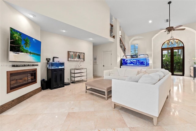 1437 SE 13th St, Deerfield Beach, FL 33441 - living area with a glass covered fireplace, a towering ceiling, a ceiling fan, arched walkways, and light marble finish floors