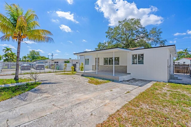 1246 Sharazad Blvd, Opa-Locka, FL 33054 - view of front of property featuring stucco siding, a porch, and a gate