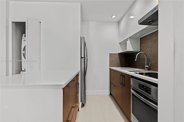 2715 Tigertail Ave Unit 102, Miami, FL 33133 - kitchen featuring appliances with stainless steel finishes, light tile patterned floors, a sink, light countertops, and modern cabinets