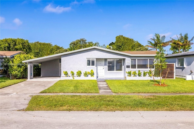 2111 NE 14th Ct, Hollywood, FL 33020 - view of front of house featuring a front lawn, concrete driveway, stucco siding, and an attached carport