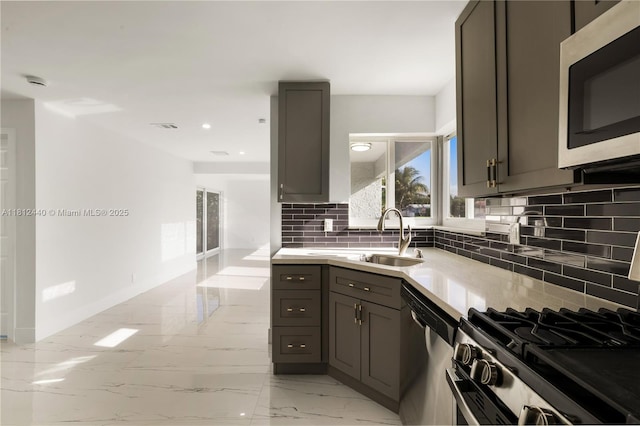 2111 NE 14th Ct, Hollywood, FL 33020 - kitchen with appliances with stainless steel finishes, gray cabinetry, a sink, light countertops, and backsplash