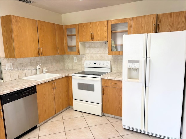 3564 Magellan Cir Unit 213-1, Aventura, FL 33180 - kitchen featuring white appliances, a sink, tile countertops, tasteful backsplash, and light tile patterned floors