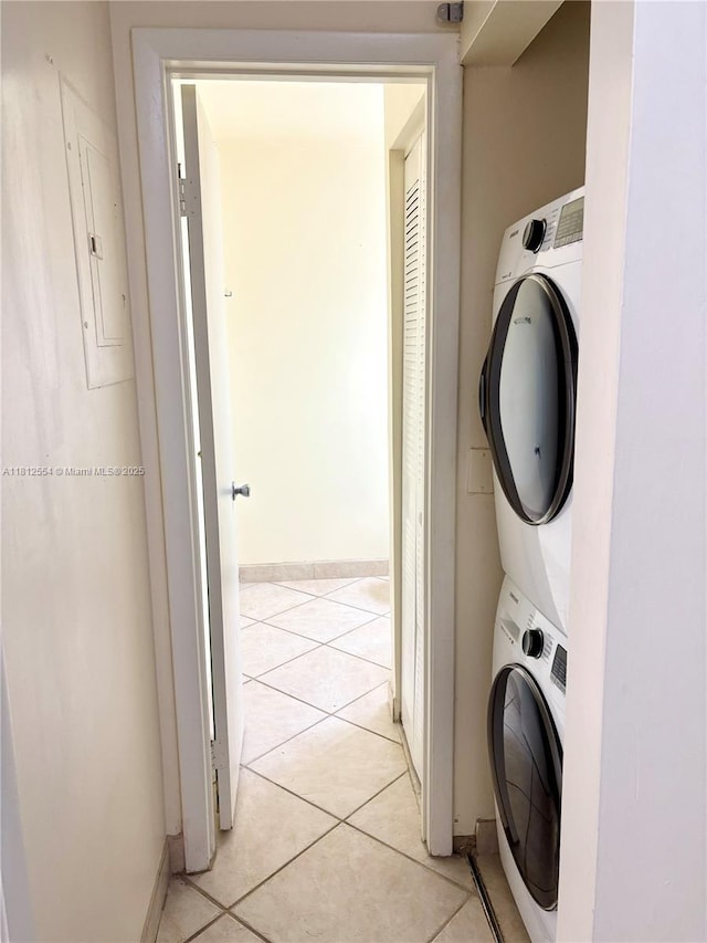 3564 Magellan Cir Unit 213-1, Aventura, FL 33180 - laundry area featuring stacked washer / drying machine, electric panel, baseboards, and light tile patterned flooring